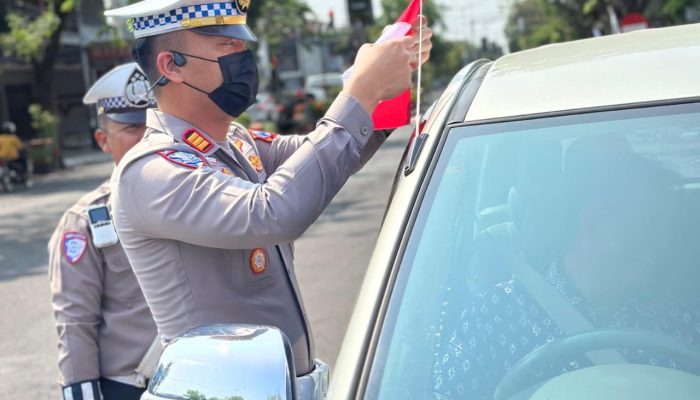 Semarak Jelang Hari Kemerdekaan RI ke -80, Polisi Berbagi Bendera Merah Putih di Nganjuk