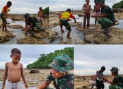Personel Satgas TMMD Bermain dan Mencari Ikan Bersama Anak-anak Saat Air Laut Surut